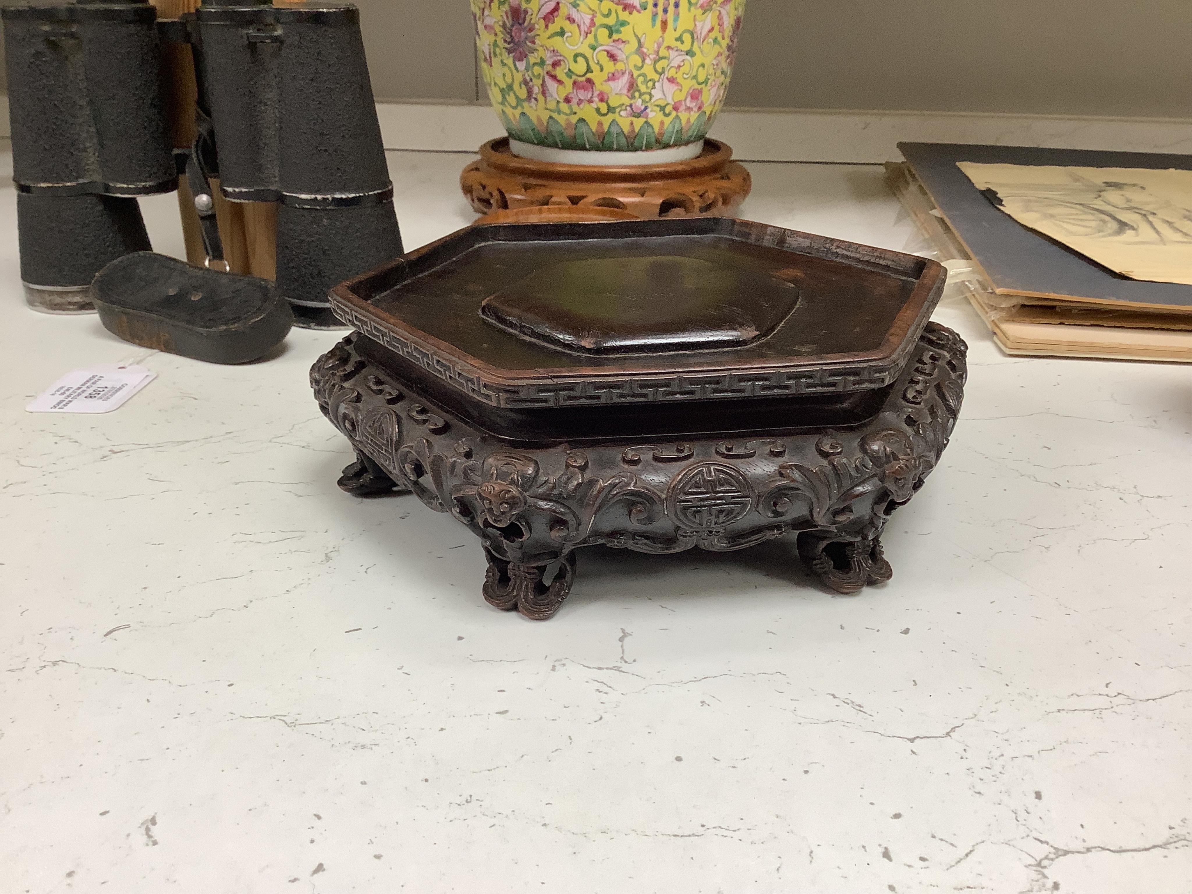 A Chinese famille rose vase and cover, late 19th century, together with a good carved hongmu ‘bats and shou’ stand, vase 36cm. Condition - crack to rim